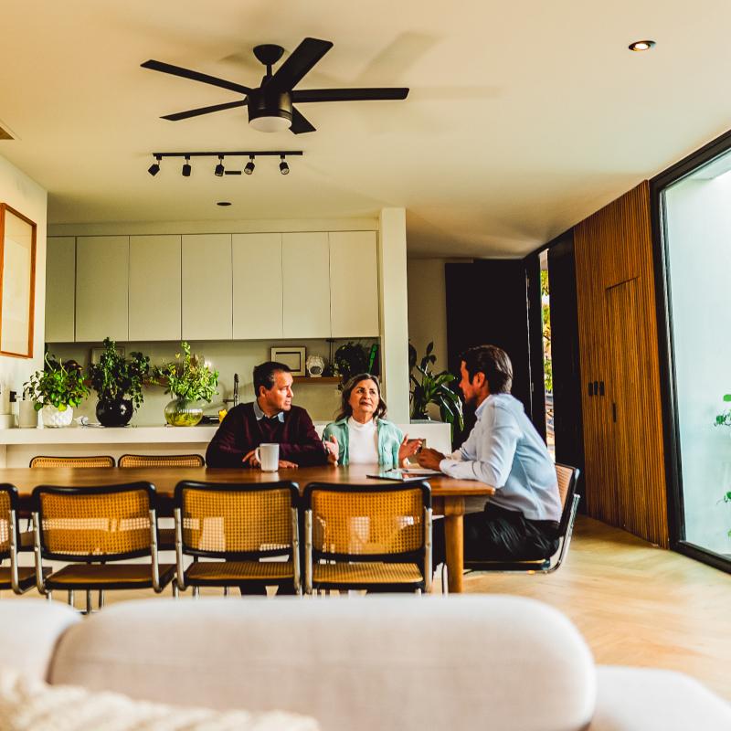 Couple meeting a financial adviser in a spacious modern home