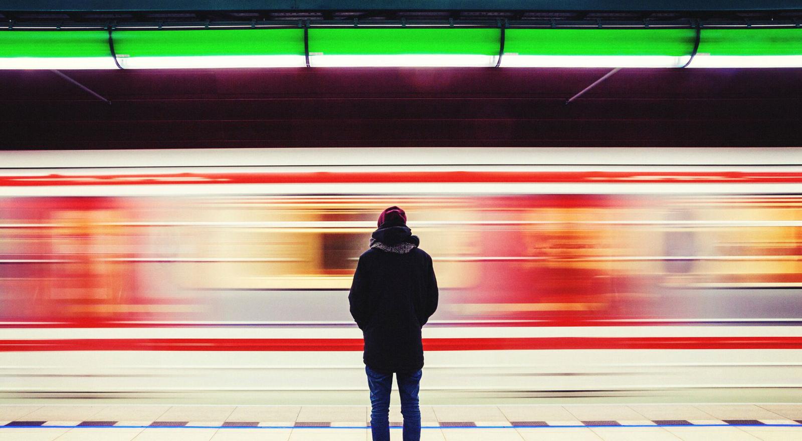 Large Web and Screen Back view of a person standing on a subway platform while the metro passes by