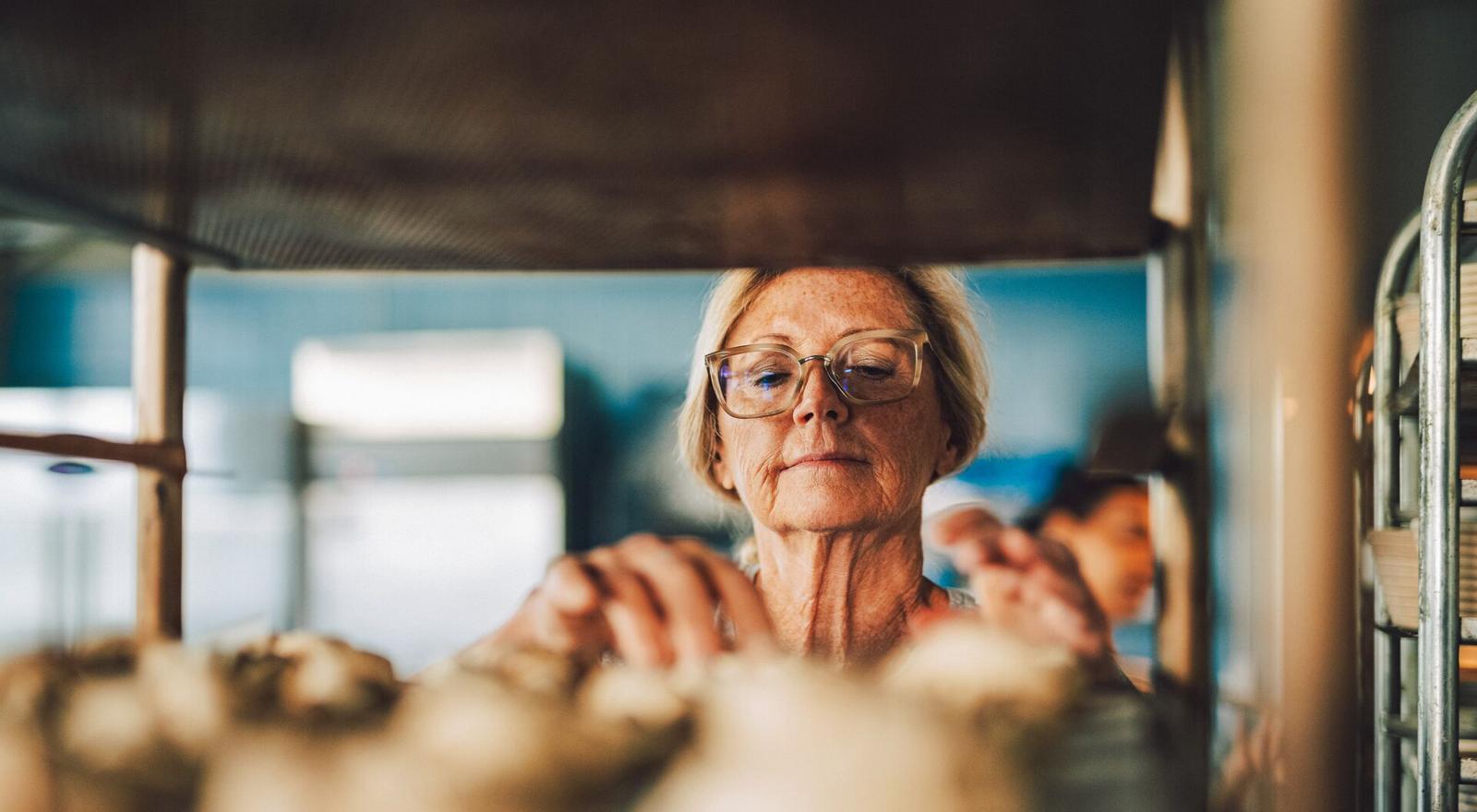 Large Web and Screen Senior baker checks on bread