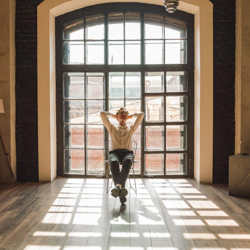 Man sits back on chair in loft