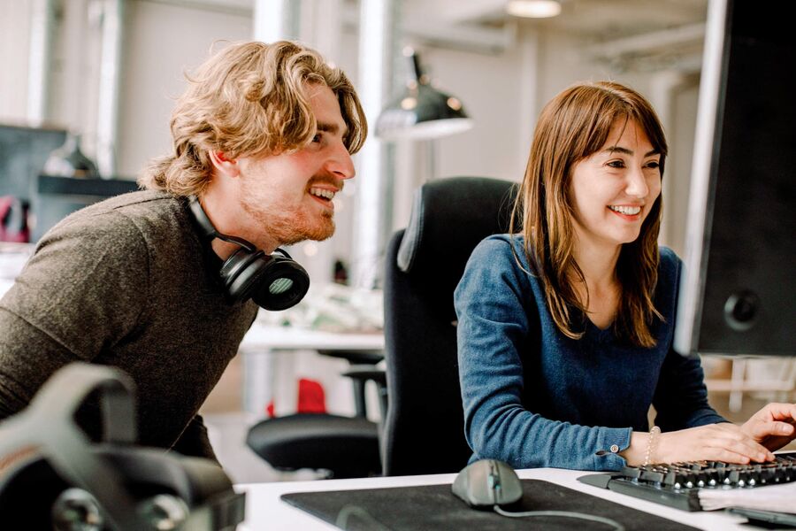 Smiling young man and woman at a desk in an office