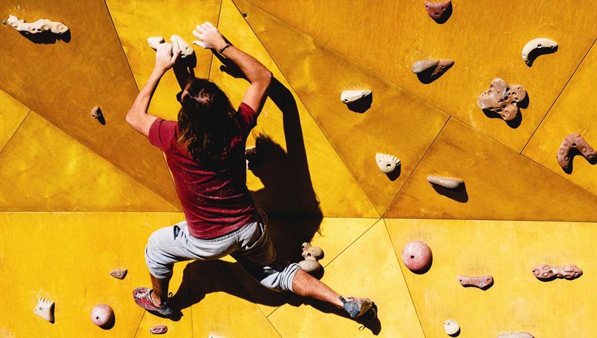 Young man climbs on outdoor climbing wall 1200x680