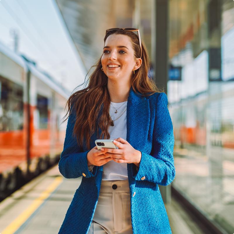 Young worker at train station on phone